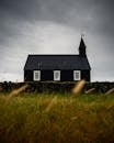 Moody landscape of the historic Black Church amidst grassy Icelandic countryside.