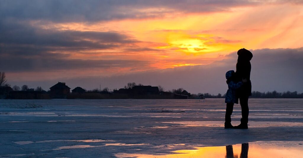A serene sunset scene of a family silhouette on a frozen lake in Kherson, Ukraine.